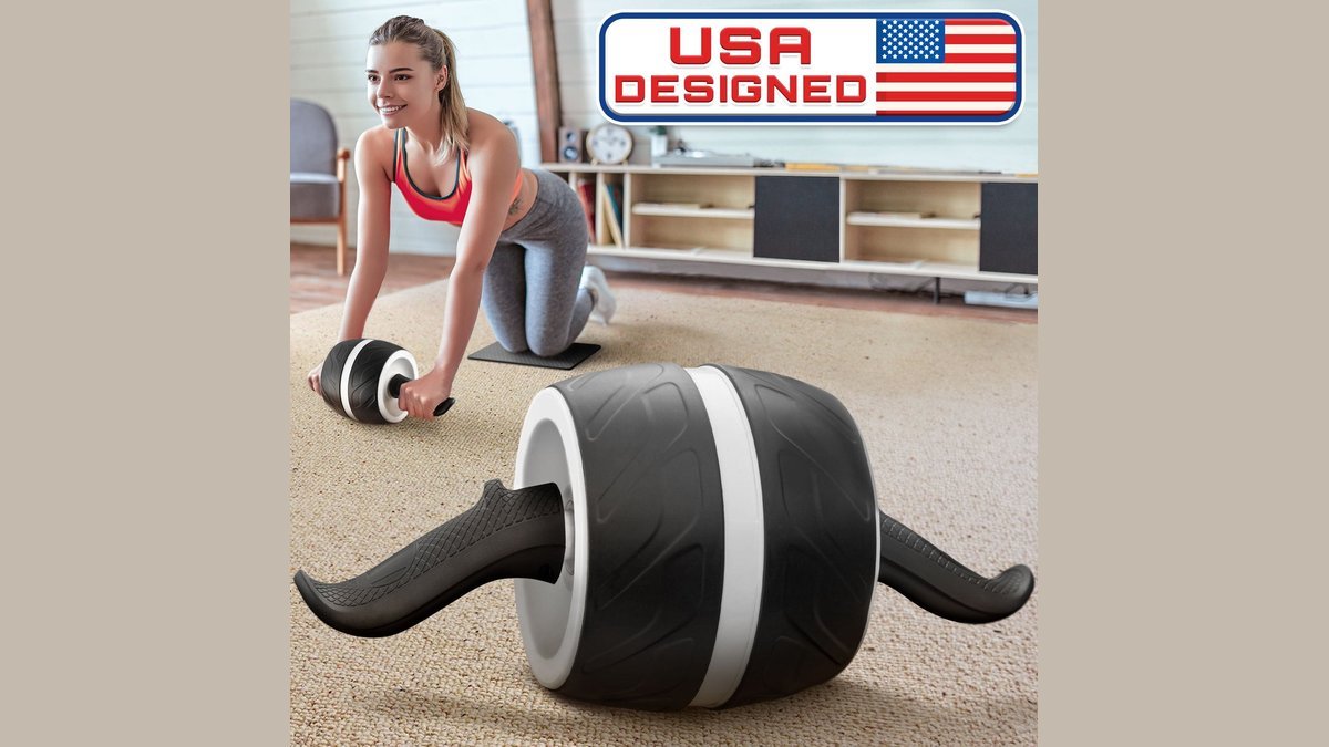 Chrome ab roller wheel on white yoga mat in modern gym
